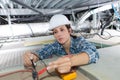 Female electrician calibrating ceiling lamps