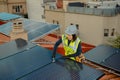Female electrician engineer installing photovoltaic Solar Panels on city rooftop Royalty Free Stock Photo