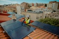 Female electrician engineer installing photovoltaic Solar Panels on city rooftop Royalty Free Stock Photo