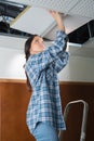 female electrician fixing ceiling lighting Royalty Free Stock Photo