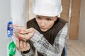 Female electrician fixing electric cables in socket Royalty Free Stock Photo