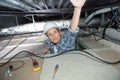 female electrician installing ventilation in ceiling Royalty Free Stock Photo