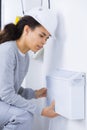 Female electrician installing wall radiator