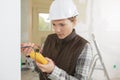 female electrician measuring voltage socket in new building Royalty Free Stock Photo
