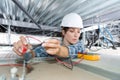 female electrician using multimeter to test spotlight Royalty Free Stock Photo