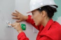 female electrician using screwdriver on wall fitting Royalty Free Stock Photo