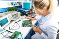 Female electronic engineer testing computer motherboard in labor