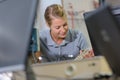 female electronics worker viewed between two computor monitors