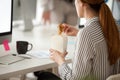 Female employee eating Asian noodles during office work break Royalty Free Stock Photo