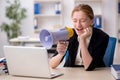 Young female employee holding megaphone in the office Royalty Free Stock Photo