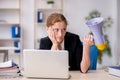 Young female employee holding megaphone in the office Royalty Free Stock Photo