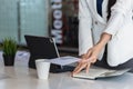 A female employee holds a white envelope to give to her manager after she decides to quit to pursue her own business. The concept