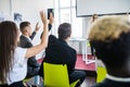 Female employee raise hand asking question to businesswoman making flipchart presentation. Young woman answering during Royalty Free Stock Photo