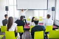 Female employee raise hand asking question to businesswoman making flipchart presentation. Young woman answering during Royalty Free Stock Photo