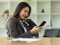 Female employee relaxed on her smartphone, scrolling through social media
