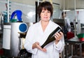 Female employee showing wine bottle at sparkling wine factory Royalty Free Stock Photo