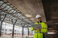 Female engineer checking building documentation on clipboard at construction site. Royalty Free Stock Photo
