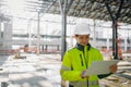 Female engineer checking building documentation on clipboard at construction site. Royalty Free Stock Photo
