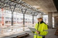 Female engineer checking building documentation on clipboard at construction site. Royalty Free Stock Photo