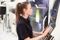 Female Engineer Operating CNC Machinery On Factory Floor