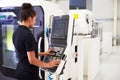 Female Engineer Operating CNC Machinery On Factory Floor