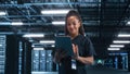 Female Engineer Programs while Holding Tablet Computer and Typing at the Screen. She Works in a Da Royalty Free Stock Photo