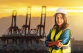 Female engineer standing in front sea port cargo crane harbor terminal Royalty Free Stock Photo