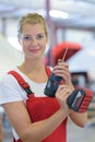 female engineer using drill in factory