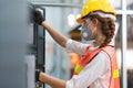 Female Engineer wear face mask with safety vest and yellow helmet operating control CNC Machinery at factory