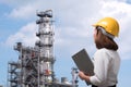 Female engineer wearing safety helmet inspects pipeline industry