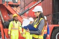 Female engineers managing cargo operations, Engineer and foreman dock worker checking containers box at shipping yard Royalty Free Stock Photo