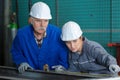 Female engineers using tape measure with senior supervisor