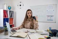 female English teacher sitting near whiteboard with rules and explains a new lesson topic Royalty Free Stock Photo