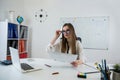 female English teacher sitting near whiteboard with rules and explains a new lesson topic Royalty Free Stock Photo