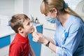 Female ENT doctor taking off or putting on a protective face mask from a boy patent before medical examination Royalty Free Stock Photo