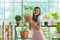 Female entrepreneur gardener in apron holding a rattan basket plant pot at the floral shop