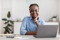 Female Entrepreneur. Portrait of young black businesswoman sitting at desk in office Royalty Free Stock Photo