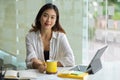 Female entrepreneur sits at her office work station with portable tablet