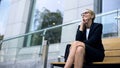 Female entrepreneur sitting on bench, smiling, rejoicing at successful day Royalty Free Stock Photo