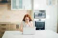 Female entrepreneur thinking while working at table in her kitchen at home