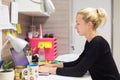 Female entrepreneur working on laptop in colorful modern creative working environment.