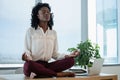 Female executive meditating on desk Royalty Free Stock Photo