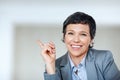 Female executive pointing at something. Portrait of mature business woman smiling while pointing at something. Royalty Free Stock Photo