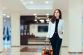 Elegant Business Woman with Travel Trolley Luggage in Hotel Lobby