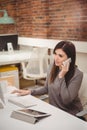 Female executive talking on mobile phone at desk Royalty Free Stock Photo