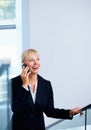 Female executive talking on phone. Business woman walking up stairs while using cell phone. Royalty Free Stock Photo