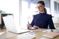 Female executive working over laptop and graphic tablet at her desk Royalty Free Stock Photo