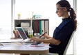 Female executive working over laptop and graphic tablet at her desk Royalty Free Stock Photo