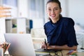 Female executive working over laptop and graphic tablet at her desk Royalty Free Stock Photo