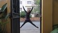 Female exercising during corona virus pandemic. She is doing star jumps outside her house and is wearing a pink face mask Royalty Free Stock Photo